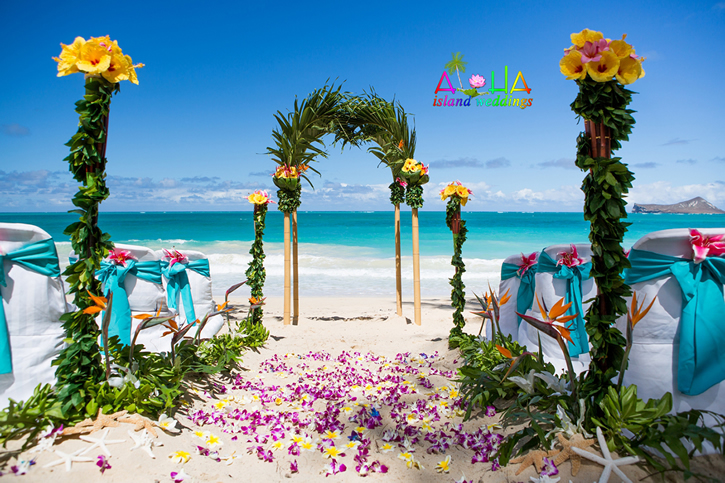 Hawaiian palm arch with bamboo brids of paradise green laupaka and yellow and pink hibiscus for the tropcial Hawaiian feel